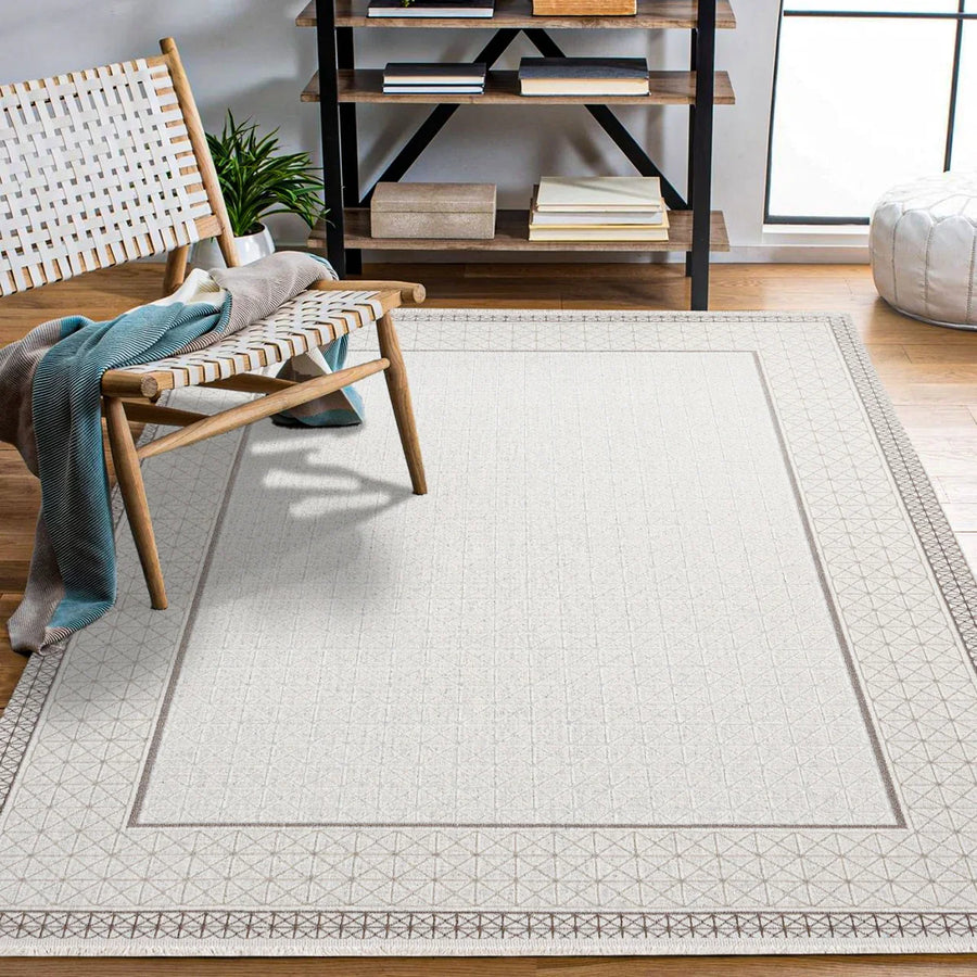Cremefarbener Teppich mit geometrischem Muster in Grau – im Wohnzimmer
