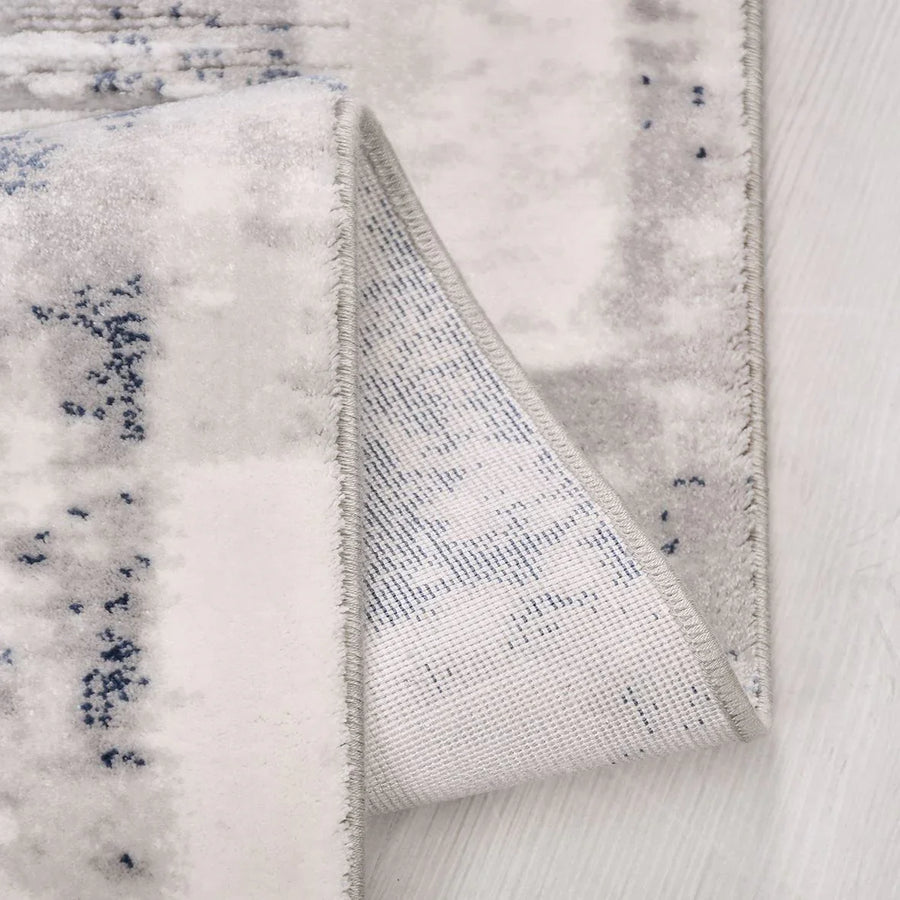 Waschbarer Teppich in Weiß & Marineblau mit abstraktem Muster – im Wohnzimmer