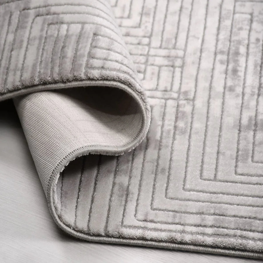 Grauer Teppich mit geometrischem Muster & samtweicher Haptik – im Wohnzimmer