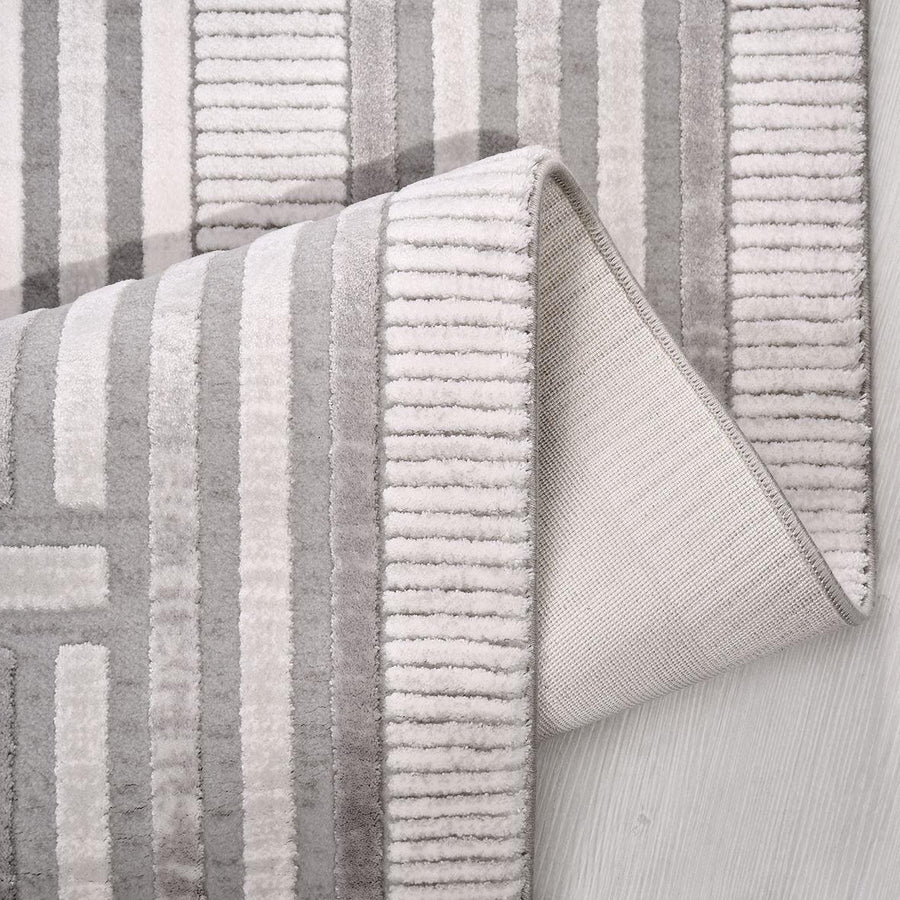 Minimalistischer grauer Teppich mit geometrischer Struktur – im Wohnzimmer