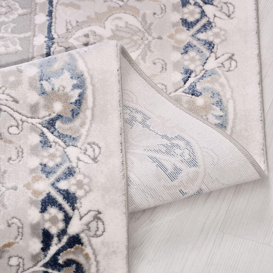 Klassischer Teppich in Grau mit marineblauem Medaillon – im Wohnzimmer