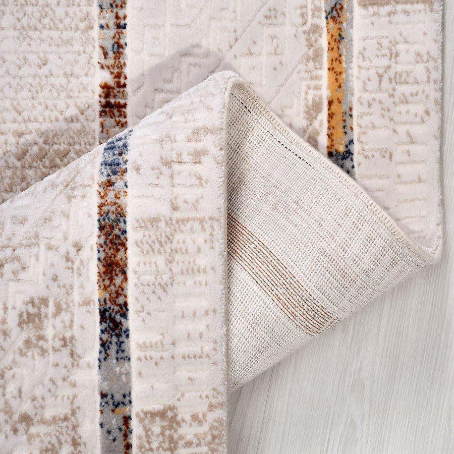 Cremefarbener Teppich mit abstraktem Muster in Beige – im Wohnzimmer